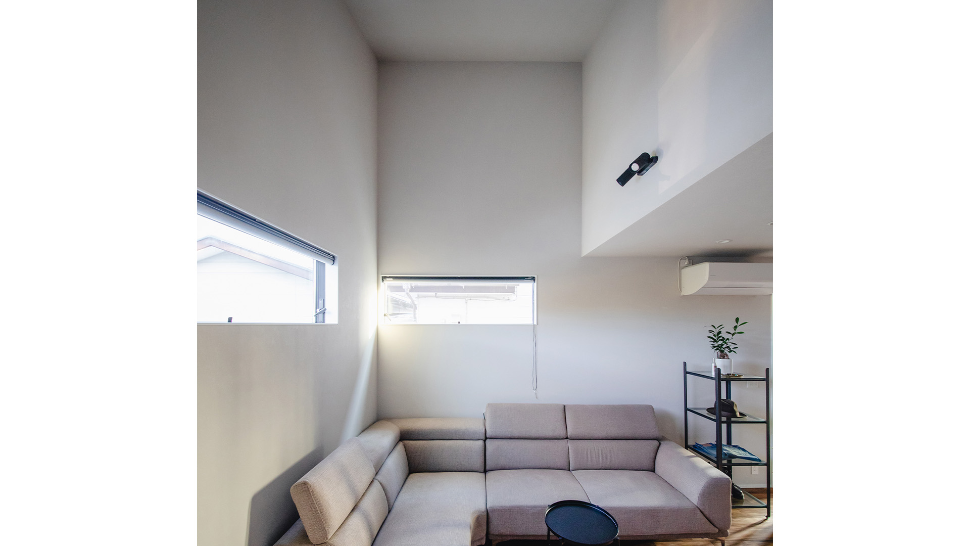 リビングルームのソファと高く設計した天井の画像。